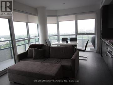 Toronto (Mount Pleasant West) condo for rent - A living room with a brown couch and a television.