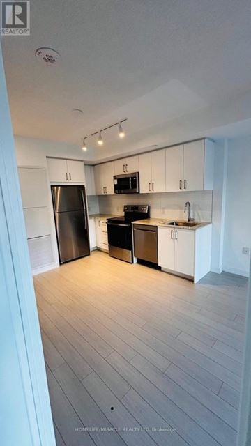 Toronto (Humber Heights) condo for rent - A kitchen with white cabinets and a wooden floor.