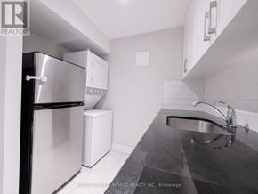 Toronto (The Beaches) apartment for rent - A kitchen with a stainless steel refrigerator and a black granite countertop.
