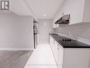 Toronto (The Beaches) apartment for rent - A kitchen with white cabinets and a black countertop.