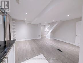 Toronto (The Beaches) apartment for rent - A spacious room with a staircase leading to the second floor.