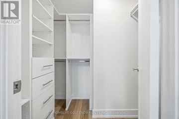 Markham (Unionville) condo for rent - A white bedroom with a built in wardrobe and drawers.