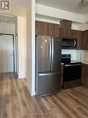 Waterloo condo for rent - A stainless steel refrigerator with a freezer drawer is in a kitchen.