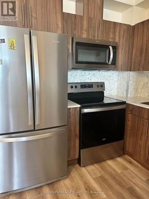 Waterloo condo for rent - A kitchen with a stainless steel refrigerator and a black oven.