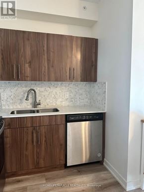Waterloo condo for rent - A kitchen with wooden cabinets and a stainless steel dishwasher.