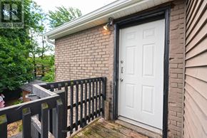 Hamilton (Corktown) duplex for rent - A white door is on a brick house with a black fence.