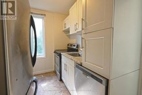 Hamilton (Corktown) duplex for rent - A kitchen with a refrigerator, microwave, and oven.