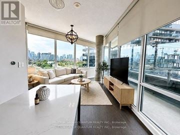 Toronto (Waterfront Communities) condo for rent - A living room with a television and a view of the city.