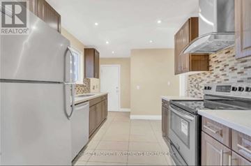 Brampton (Madoc) apartment for rent - A modern kitchen with a stainless steel refrigerator and a tiled backsplash.
