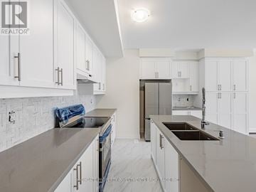 Brampton (Northwest Brampton) townhouse for rent - A modern kitchen with white cabinets and a marble countertop.
