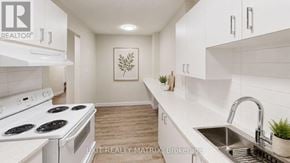 Ottawa townhouse for rent - A white kitchen with a stove top oven and a sink.