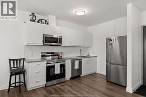 Lasalle condo for rent - A kitchen with white cabinets and stainless steel appliances.