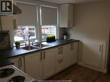 Windsor apartment for rent - A kitchen with white cabinets and a black countertop.