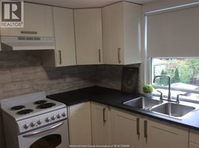 Windsor apartment for rent - A kitchen with a stove, sink, and cabinets.