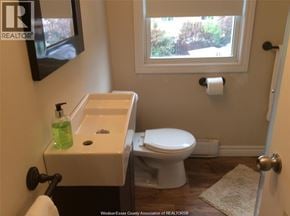 Windsor apartment for rent - A white toilet is in a bathroom with a sink and a window.