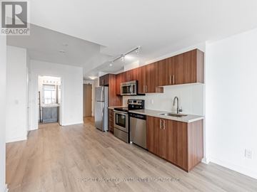 Toronto (Yorkdale-Glen Park) condo for rent - A kitchen with wooden cabinets and stainless steel appliances.