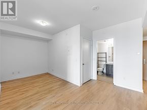 Toronto (Yorkdale-Glen Park) condo for rent - A room with white walls and wooden flooring, with a doorway leading to another room.