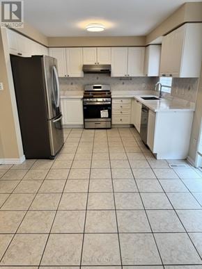 Milton (Cl Clarke) apartment for rent - A kitchen with white cabinets and a black fridge.