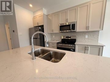 Ottawa townhouse for rent - A kitchen with a sink and a stove top oven.