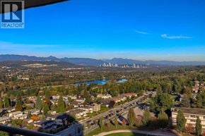 Burnaby apartment for rent - A realtor logo is visible on the top left corner of an aerial view of a residential area with a lake and mountains in the background.