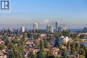Burnaby apartment for rent - A cityscape with a mountain in the background and a clear blue sky.