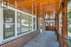 Windsor apartment for rent - A wooden porch with a brick wall and a glass door.