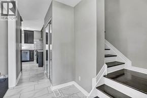 Windsor apartment for rent - A hallway with a staircase and a door leading to a bedroom.