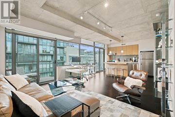 Toronto (Waterfront Communities) condo for rent - A modern living room with a brown leather couch and a glass table.