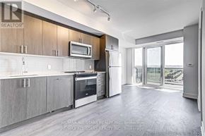 Oshawa (Windfields) condo for rent - A modern kitchen with wooden cabinets and stainless steel appliances.
