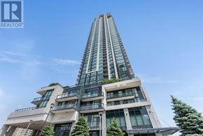 Mississauga (City Centre) condo for rent - A tall building with a glass facade and a logo that reads RE/MAX on the top left corner.