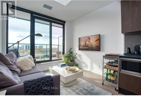 Toronto (Junction Area) condo for rent - A living room with a grey couch, a white coffee table, and a painting on the wall.