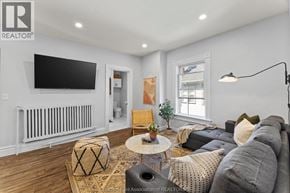 Chatham apartment for rent - A living room with a grey couch, a coffee table, and a flat screen TV mounted on the wall.