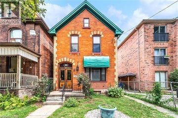 Hamilton apartment for rent - A red brick house with a green roof and a white door.