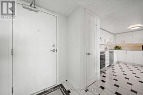 London East (East F) condo for rent - A white door with a silver handle is in a room with a black and white checkered floor.