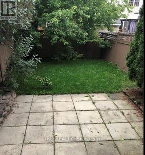 Ottawa townhouse for rent - A backyard with a patio and a fence.