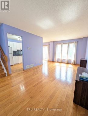 Ottawa townhouse for rent - A room with wooden floors and a staircase.