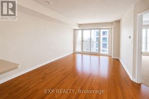 Ottawa condo for rent - A room with wooden floors and a large window overlooking a city.