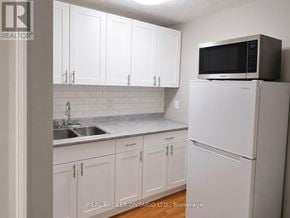 Burlington (Brant Hills) apartment for rent - A kitchen with white cabinets and a white refrigerator.