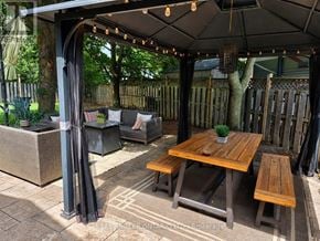 Burlington (Brant Hills) apartment for rent - A wooden table is surrounded by chairs and a canopy.
