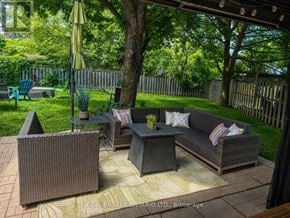 Burlington (Brant Hills) apartment for rent - A patio with a couch, chairs, and a table with a yellow umbrella.