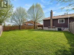 Burlington (Brant Hills) apartment for rent - A backyard with a fence and a house in the background.