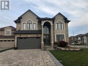 Hamilton (Carpenter) apartment for rent - A house with a grey garage door and a stone pathway leading to it.