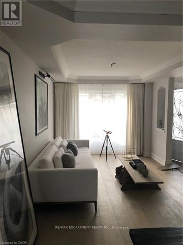 Hamilton (Carpenter) apartment for rent - A well-lit, modern living room with a white sofa and a wooden coffee table.