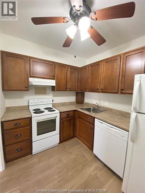 Windsor condo for rent - A kitchen with white appliances and wooden cabinets.