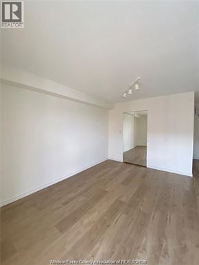 Windsor condo for rent - A room with wooden flooring and white walls.