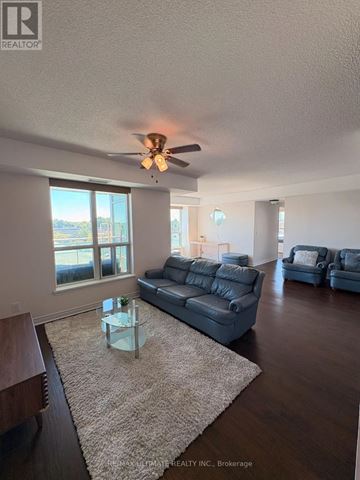 Toronto (Clairlea-Birchmount) condo for rent - A living room with a grey couch and a glass coffee table.