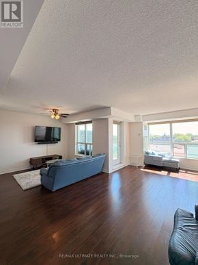 Toronto (Clairlea-Birchmount) condo for rent - A living room with a blue couch and a flat screen TV mounted on the wall.