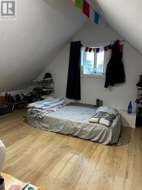 Hamilton (Beasley) apartment for rent - A bedroom with a bed, a window with curtains, and a coat hanging on the wall.