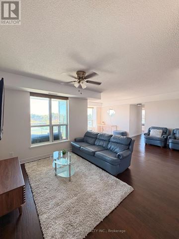Toronto (Clairlea-Birchmount) condo for rent - A living room with a grey couch and a glass coffee table.