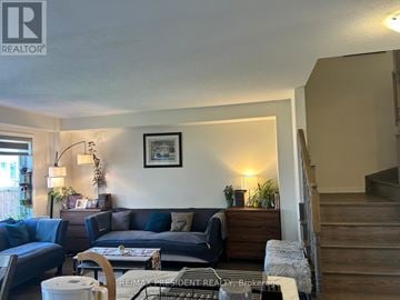 Hamilton (Binbrook) townhouse for rent - A living room with a couch, chair, and a table with a plant on it.